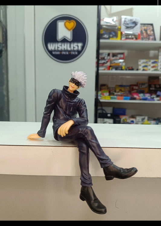 A collectible anime figurine of Satoru Gojo from Jujutsu Kaisen sitting on a white counter in a store, with a 'Wishlist' sign and shelves in the background.